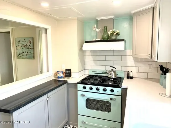 a kitchen with a stove a sink and a window