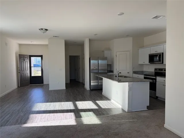 a large white kitchen with a refrigerator a stove top oven a sink and dishwasher