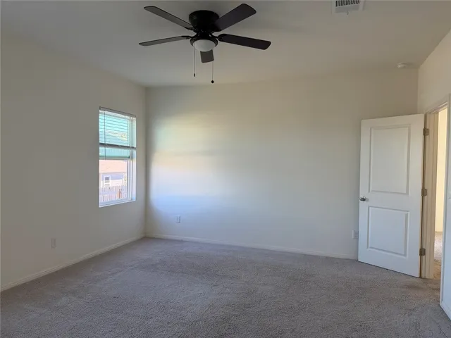 an empty room with a window and a fan
