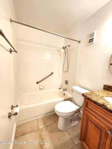 a bathroom with a granite countertop toilet sink and shower