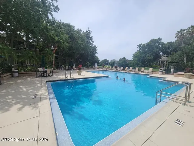 a view of a swimming pool with a yard and seating area