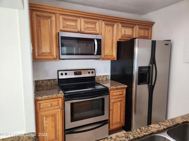 a kitchen with stainless steel appliances wooden cabinets and a stove top oven