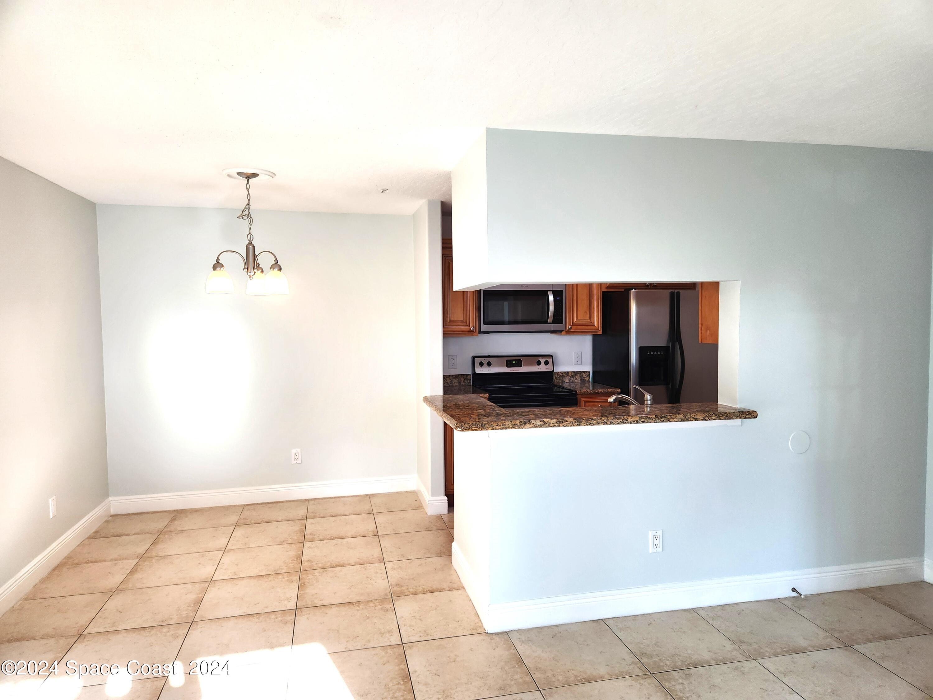 7667 North Wickham Road, Unit 601 Melbourne, FL 32940 - Photo 7 of 21 a kitchen with stainless steel appliances a refrigerator and a stove top oven