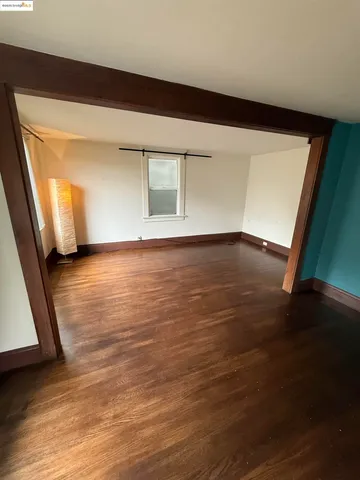 a view of a room with wooden floor a ceiling fan and a window
