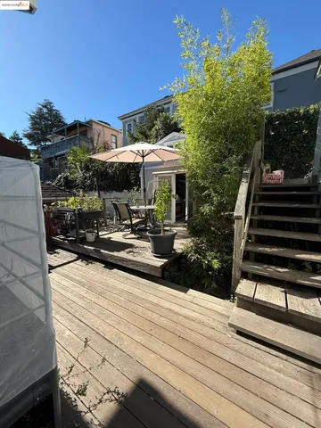 a view of a patio with table and chairs with wooden floor and plants