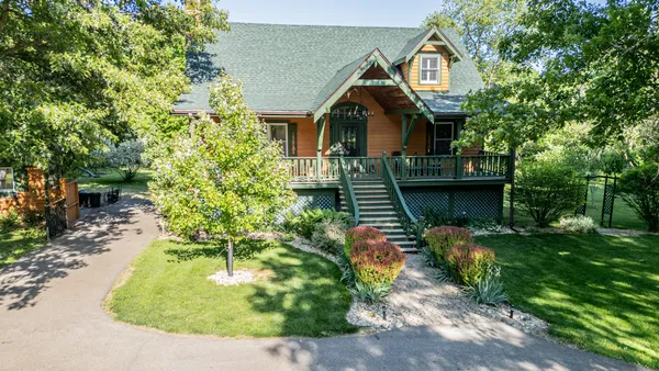 a view of a house with backyard and trees