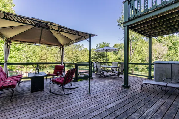 a view of deck with table and chairs under an umbrella with wooden floor