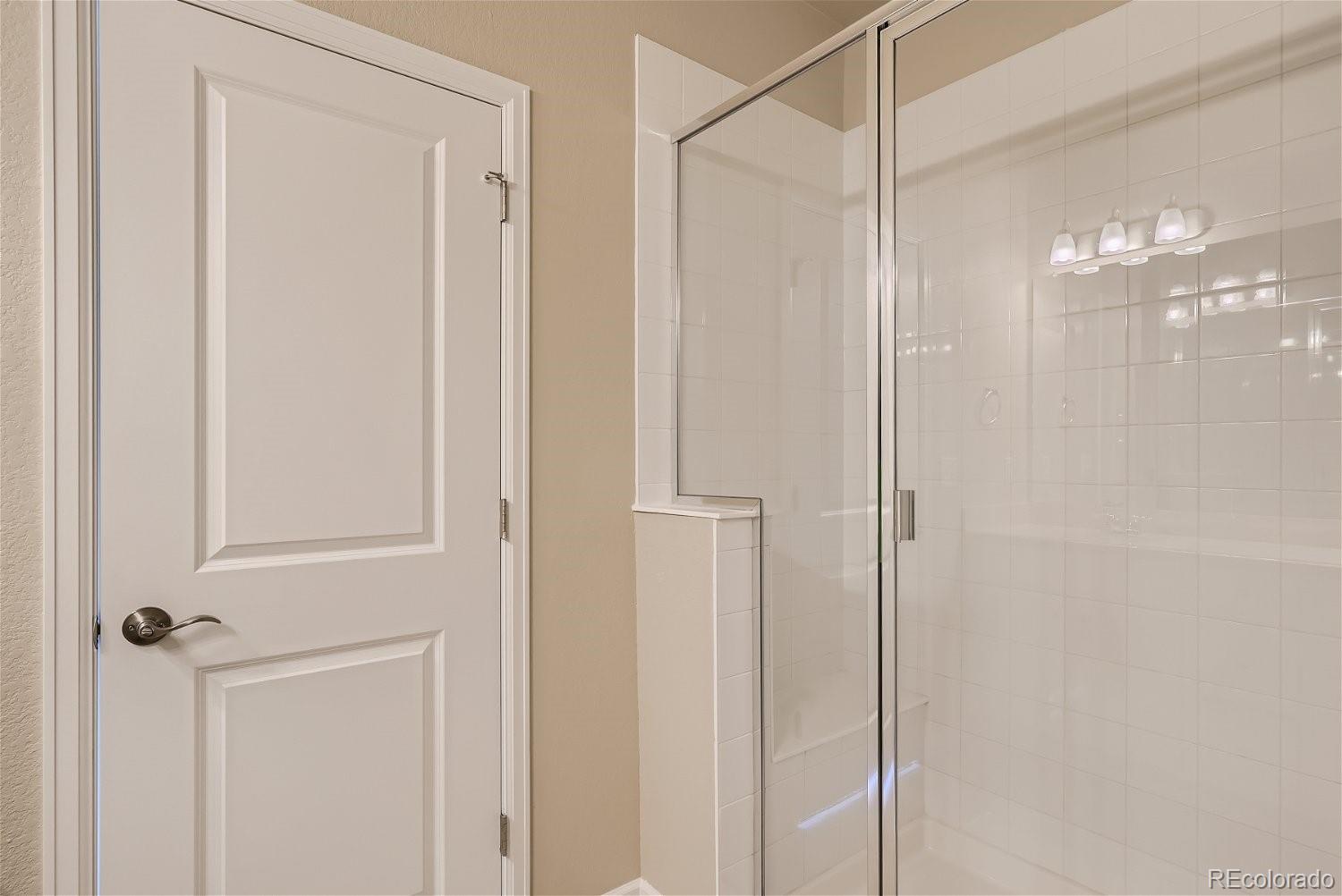 6700 Merseyside Lane Castle Pines, CO 80108 - Photo 17 of 28 a bathroom with a glass shower door