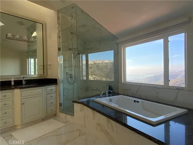 a bathroom with a tub sink and mirror