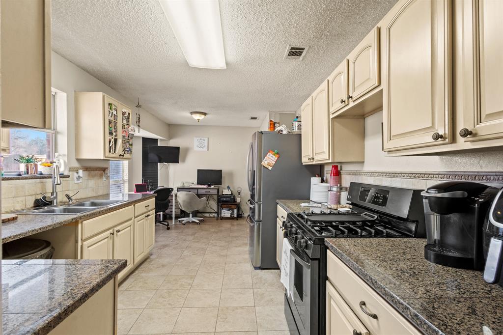 3717 Corn Valley Road Grand Prairie, TX 75052 - Photo 6 of 14 a kitchen with a stove a sink and a counter top space