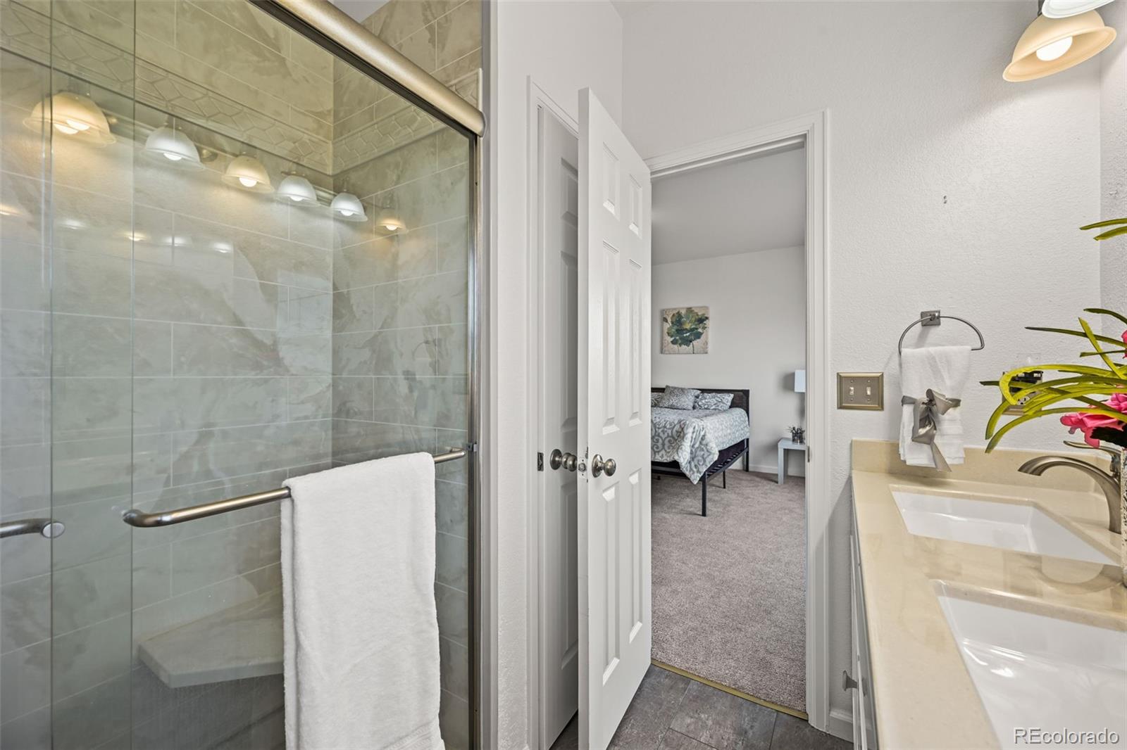 7498 Patrick Trail Elizabeth, CO 80107 - Photo 16 of 44 a en suite bathroom with a sink a mirror and shower