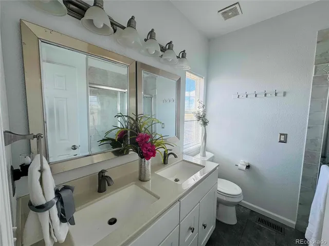 a bathroom with a sink and mirror with toilet