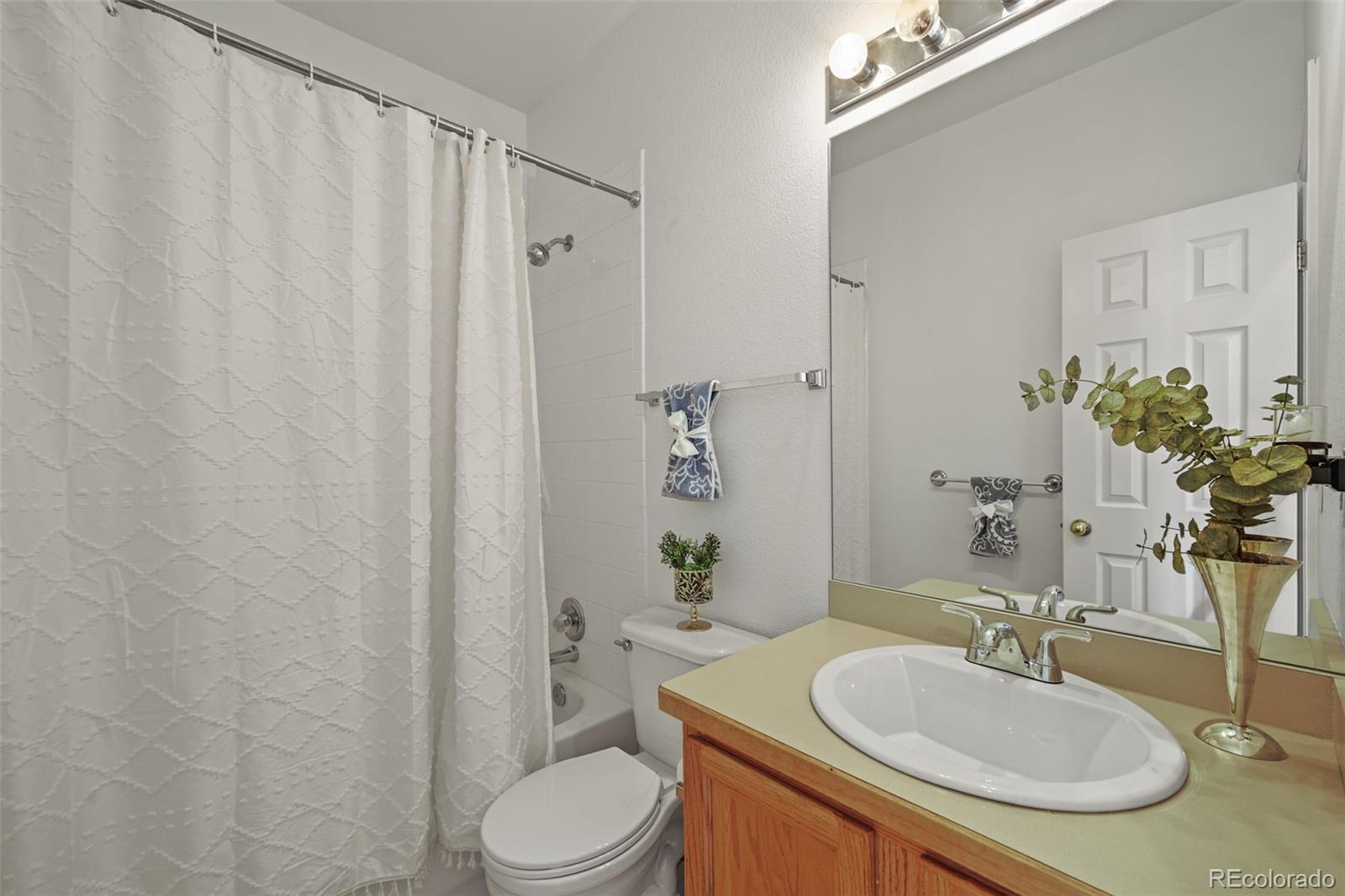 7498 Patrick Trail Elizabeth, CO 80107 - Photo 26 of 45 a bathroom with a sink a toilet and shower curtain