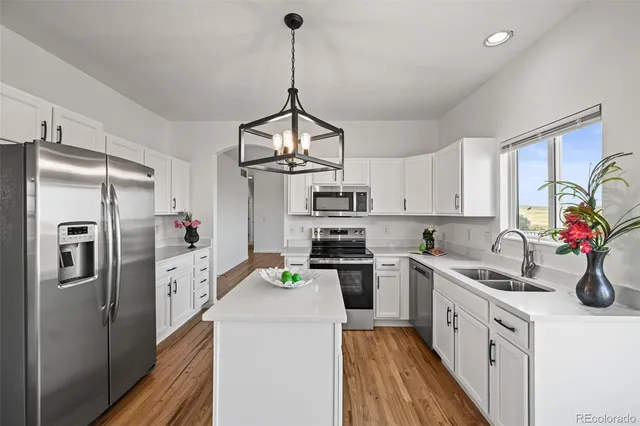 a kitchen with stainless steel appliances a sink stove and refrigerator