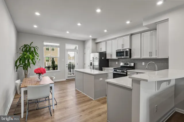 a kitchen with white cabinets and stainless steel appliances