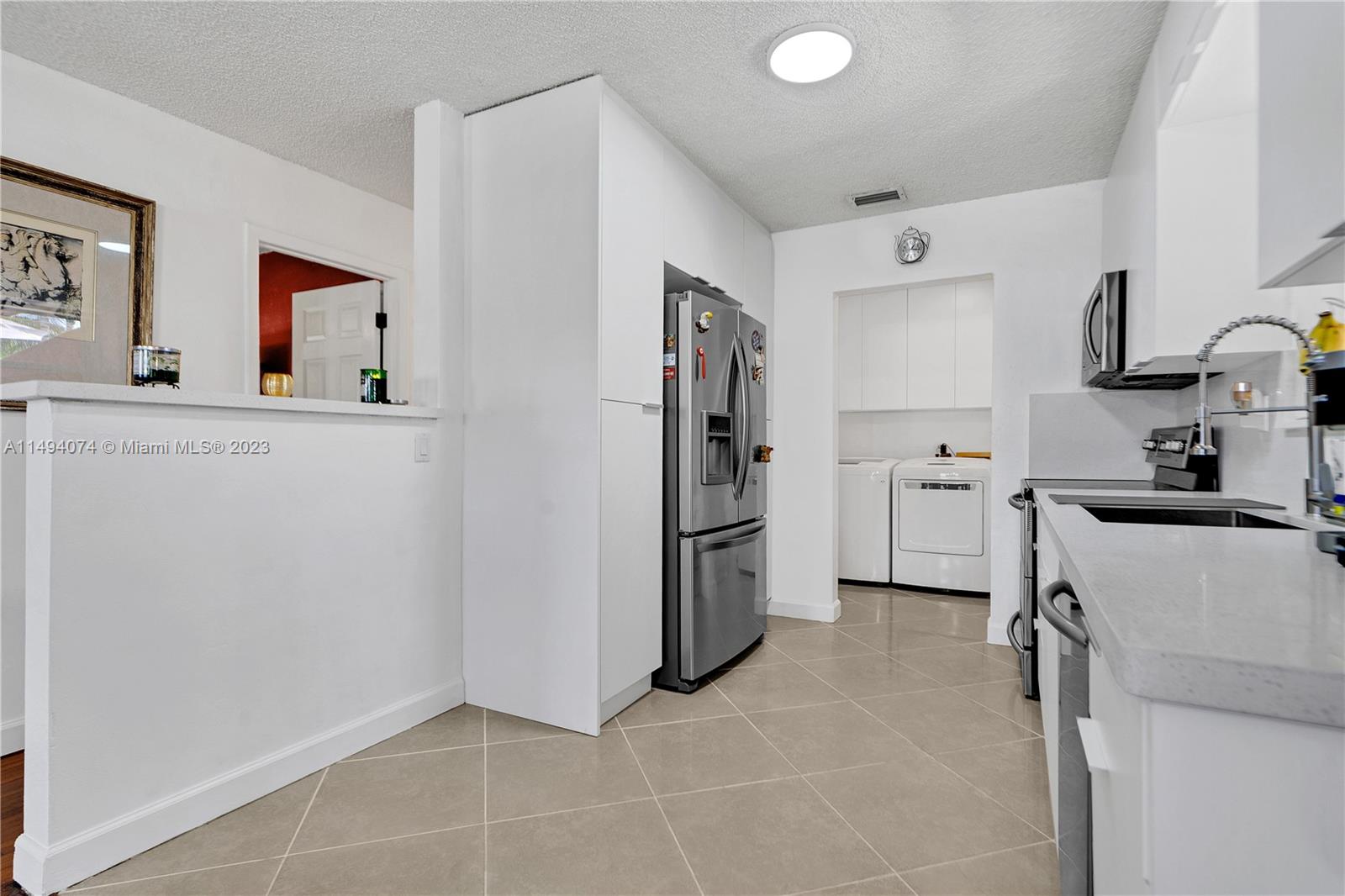 3300 Southwest 80th Avenue Miami, FL 33155 - Photo 14 of 31 a kitchen with a refrigerator and cabinets