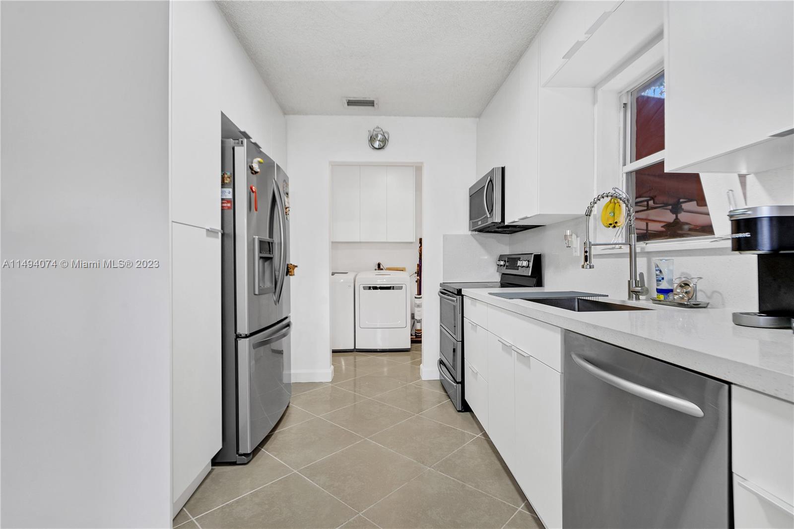 3300 Southwest 80th Avenue Miami, FL 33155 - Photo 15 of 31 a kitchen with a refrigerator and cabinets