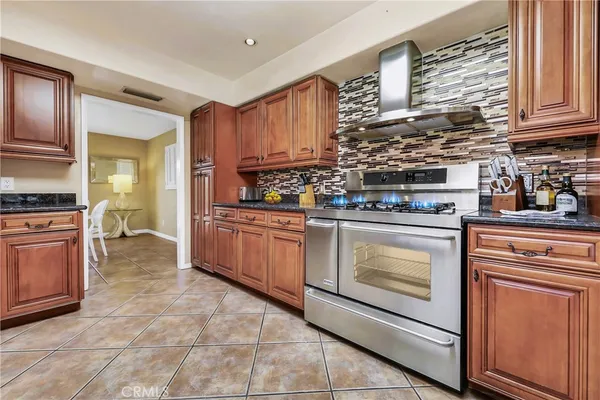a kitchen with stainless steel appliances granite countertop a stove sink and cabinets