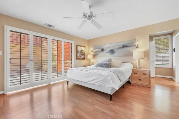a bedroom with a large bed and wooden floor