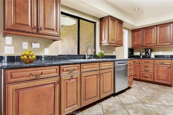 a kitchen with stainless steel appliances granite countertop a sink stove and cabinets