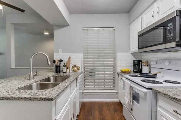 a kitchen with stainless steel appliances granite countertop a sink stove and microwave