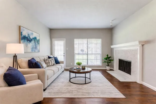 a living room with furniture a fireplace and a large window
