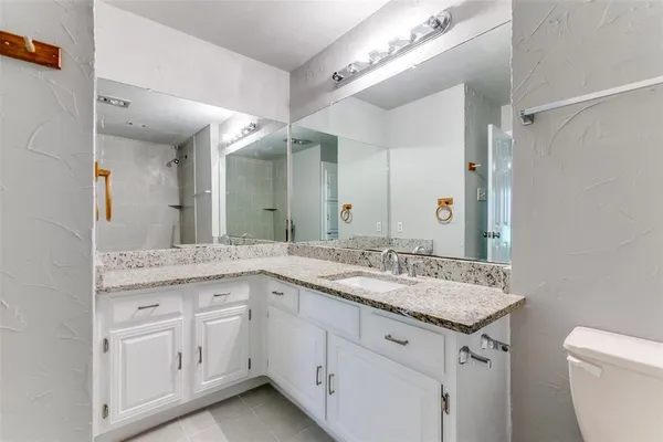 a bathroom with a granite countertop sink two mirror and a