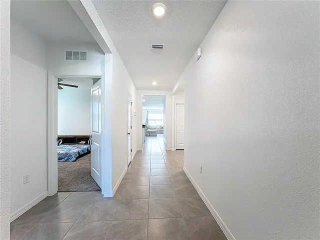 a view of a hallway with a livingroom and a bathroom