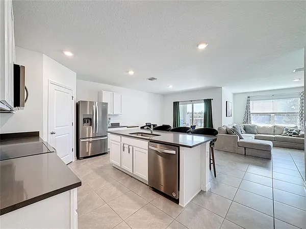 a kitchen with stainless steel appliances granite countertop a stove a sink a refrigerator and a microwave