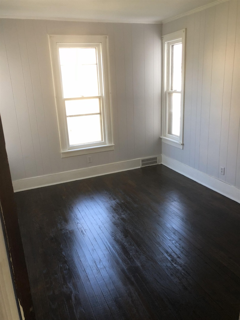 322 1st Avenue Clinton, IA 52732 - Photo 5 of 6 an empty room with wooden floor and windows