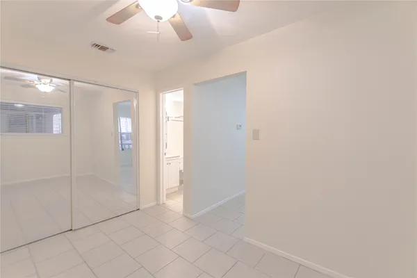 an empty room with fan and entrance