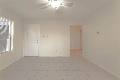 an empty room with chandelier fan