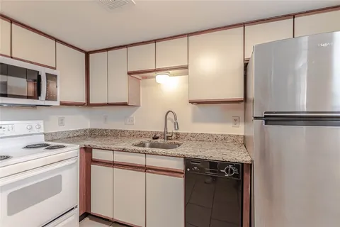 a kitchen with a refrigerator sink and cabinets