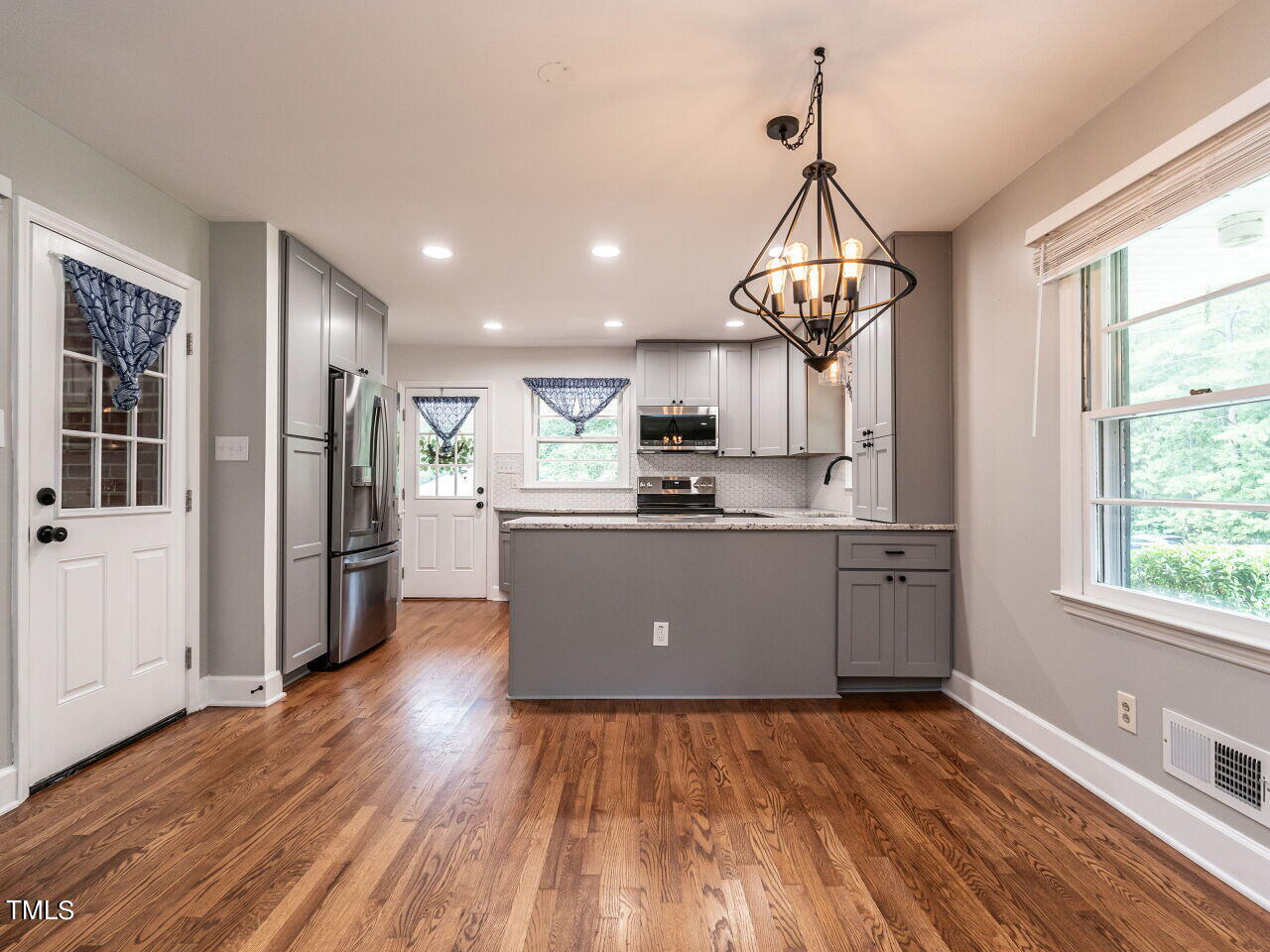 7800 White Oak Road Garner, NC 27529 - Photo 14 of 37 a kitchen with stainless steel appliances granite countertop a refrigerator a sink dishwasher a stove and a dining table with wooden floor