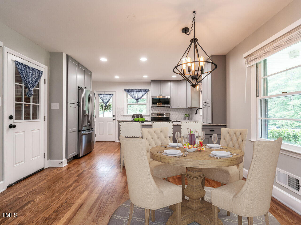 7800 White Oak Road Garner, NC 27529 - Photo 3 of 37 a view of a dining room and livingroom with furniture wooden floor kitchen view and a chandelier
