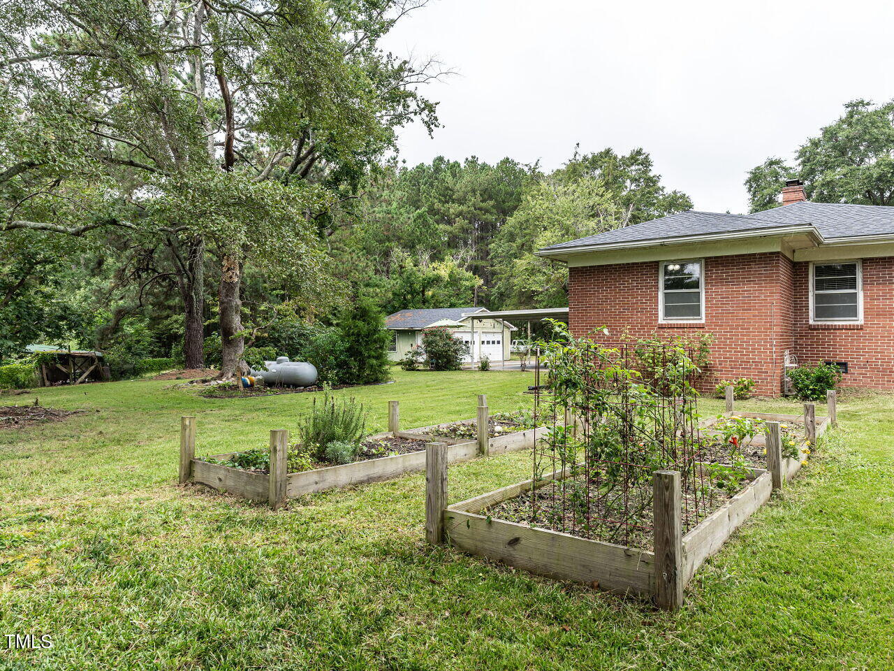 7800 White Oak Road Garner, NC 27529 - Photo 33 of 37 a view of a house with backyard sitting area and garden