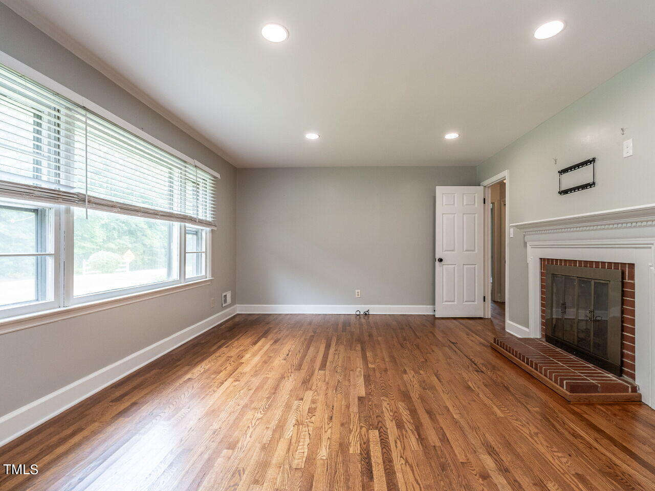 7800 White Oak Road Garner, NC 27529 - Photo 8 of 37 a view of an empty room with wooden floor and a window