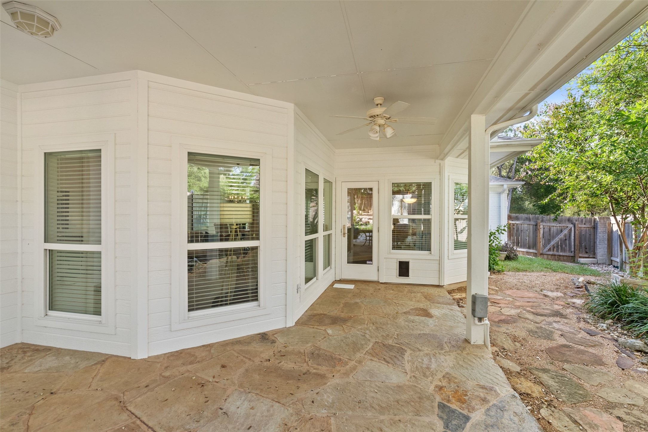 120 Copperleaf Road Lakeway, TX 78734 - Photo 24 of 30 An inviting flagstone patio offers ample space for outdoor living and entertaining, seamlessly connecting to the home's sun-filled interior.