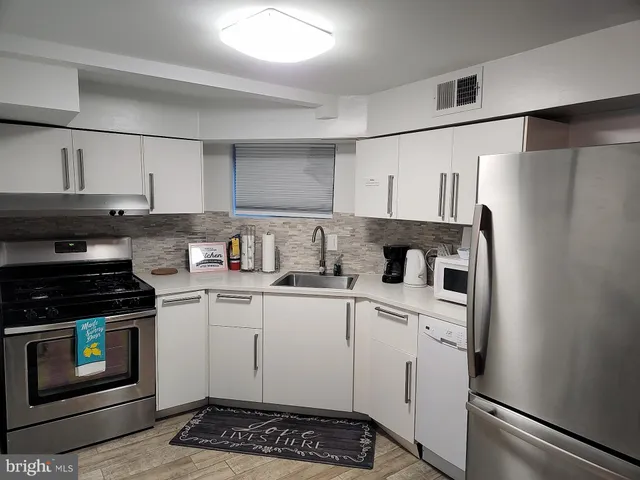 a kitchen with stainless steel appliances a stove a sink and a refrigerator