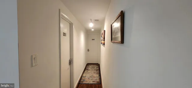 a view of a hallway with wooden floor and staircase