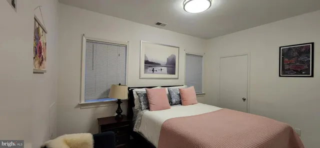 a bedroom with a bed and a painting on the wall