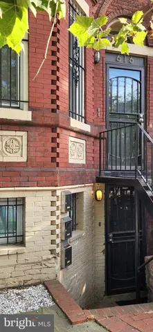 a front view of a building with a garden and plants