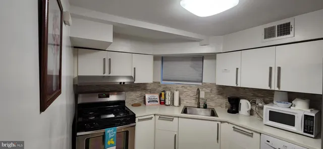 a kitchen with stainless steel appliances a stove a sink a refrigerator and cabinets