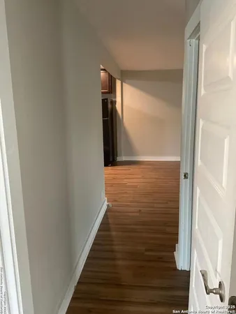 a view of a hallway with wooden floor and staircase