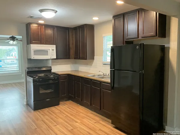 a kitchen with granite countertop stainless steel appliances and wooden cabinets
