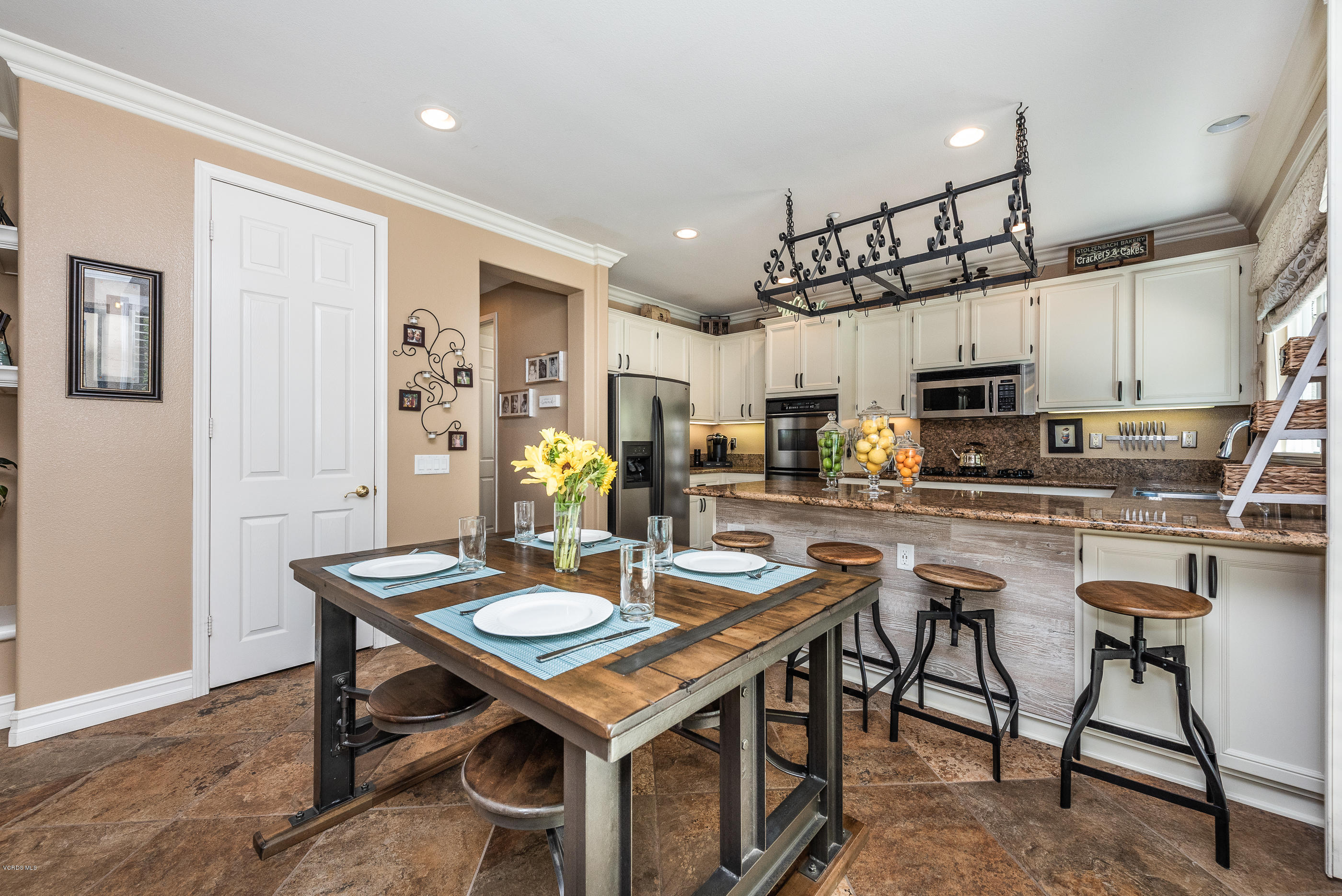 1469 Hidden Ranch Drive Simi Valley, CA 93063 - Photo 18 of 49 a kitchen with stainless steel appliances a dining table chairs and stove top oven
