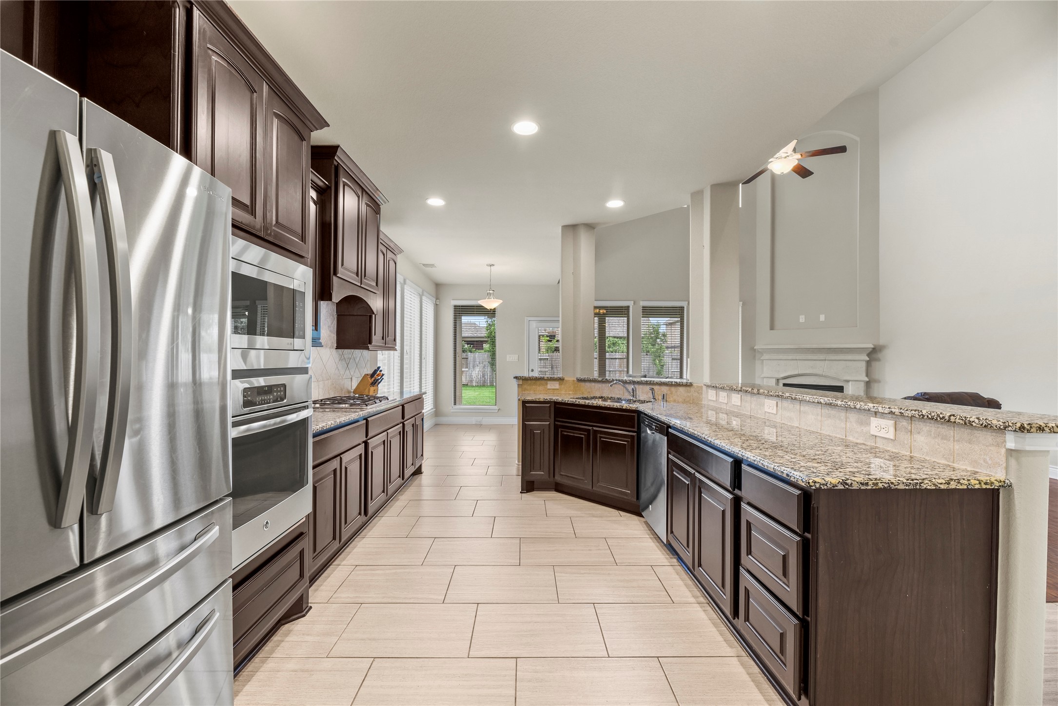 3834 Trophy Ridge Drive Spring, TX 77386 - Photo 13 of 43 a large kitchen with stainless steel appliances granite countertop a stove top oven a sink and dishwasher