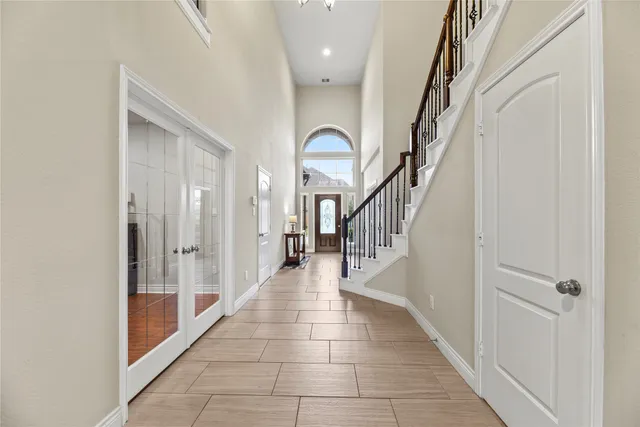 a hallway with wooden floor windows and stairs