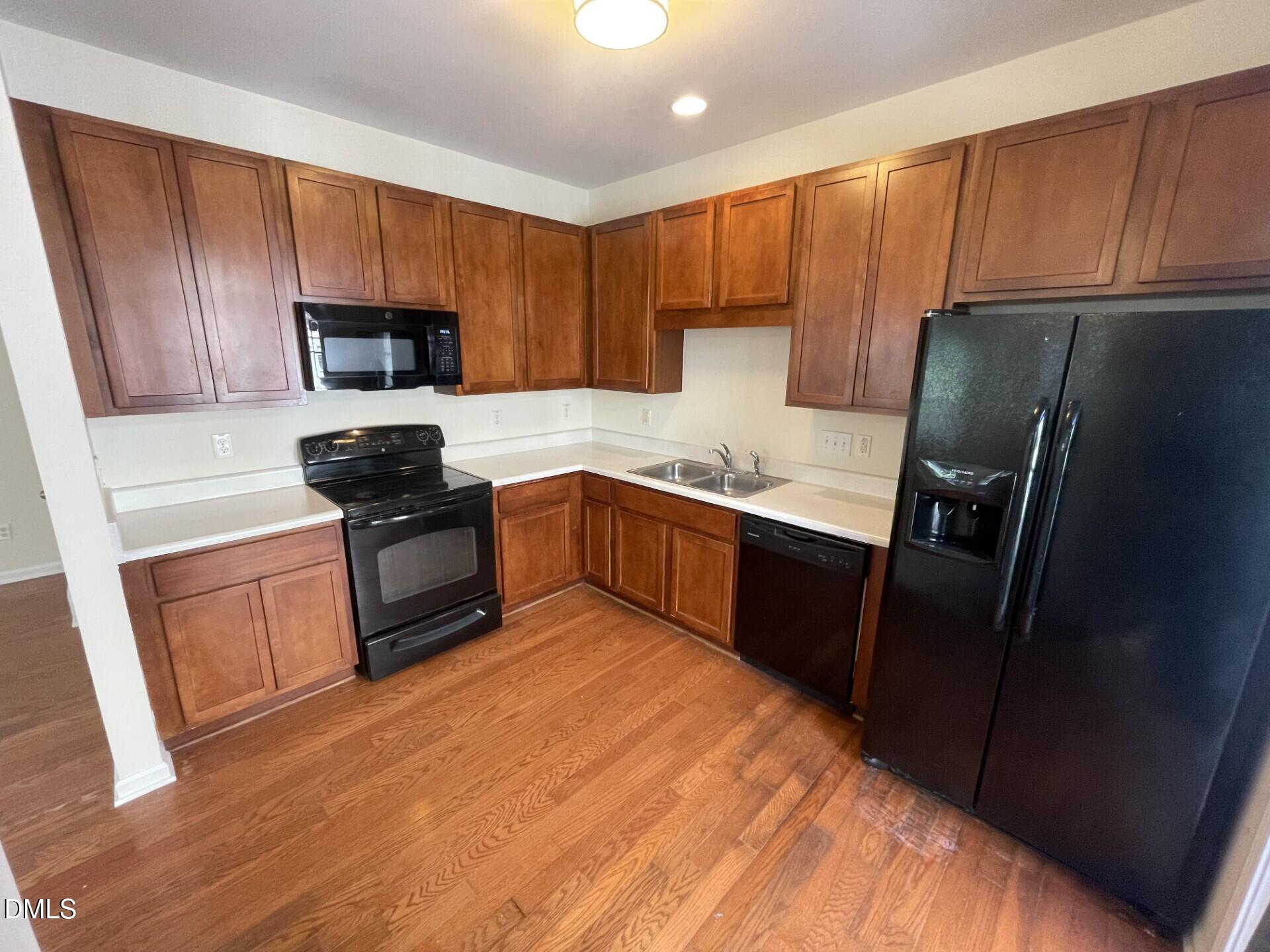 1130 Renewal Place, Unit 100 Raleigh, NC 27603 - Photo 3 of 17 a kitchen with a sink a stove a refrigerator and cabinets