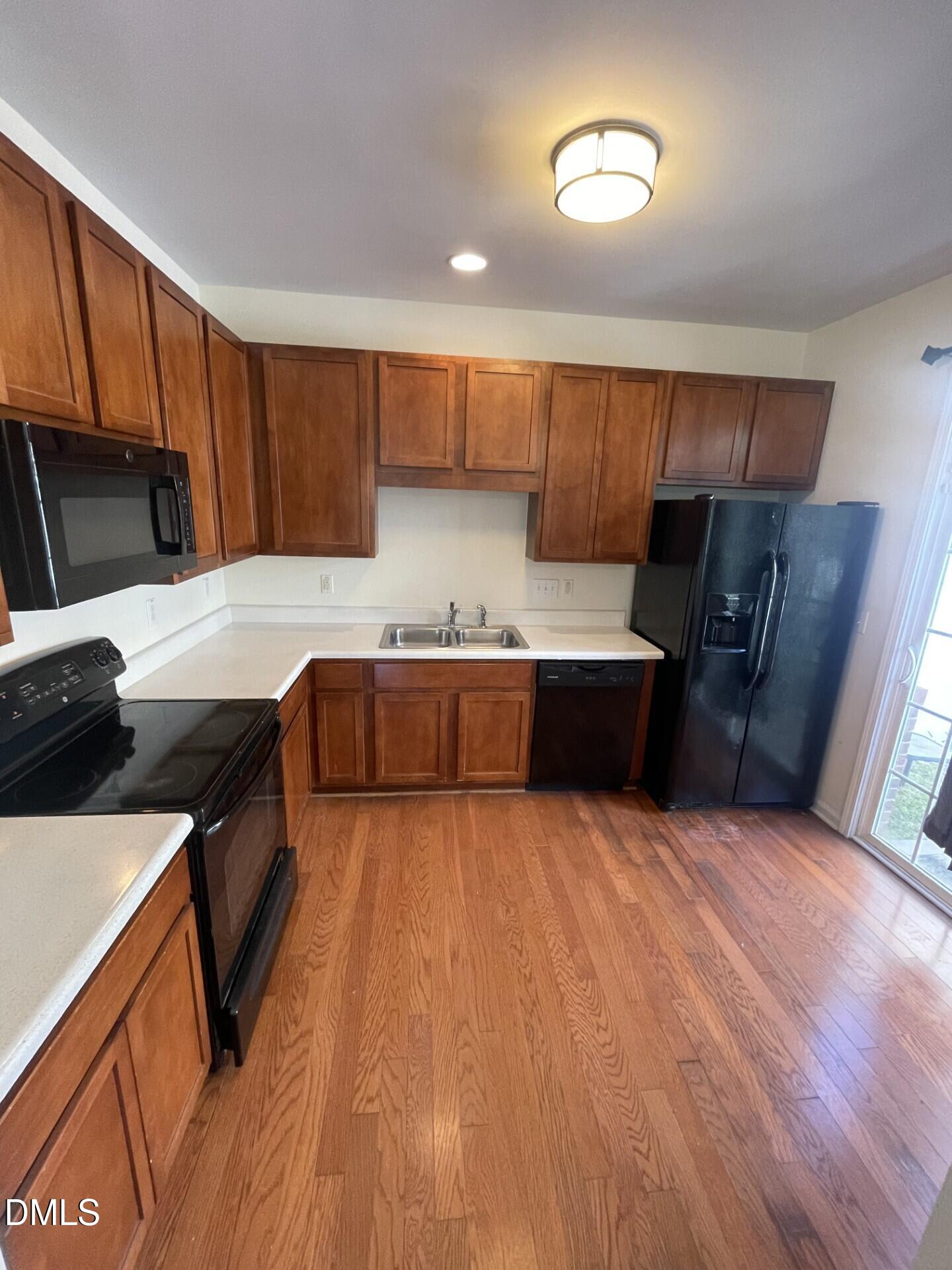 1130 Renewal Place, Unit 100 Raleigh, NC 27603 - Photo 5 of 17 a kitchen with stainless steel appliances wooden cabinets and a refrigerator